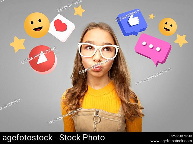 teenage girl in glasses looking at internet icons