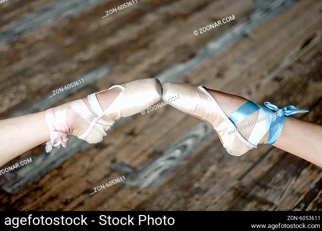 Pointed feet in ballet shoes touching toes