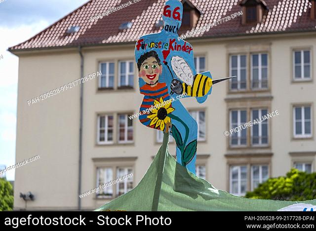 16 May 2020, Saxony-Anhalt, Magdeburg: There's a sign that says ""GG for our children too."" In the state capital people demonstrated in the old market against...
