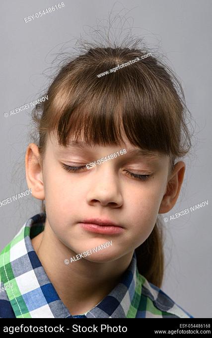 Portrait of a ten-year-old girl with closed eyes, European appearance, close-up