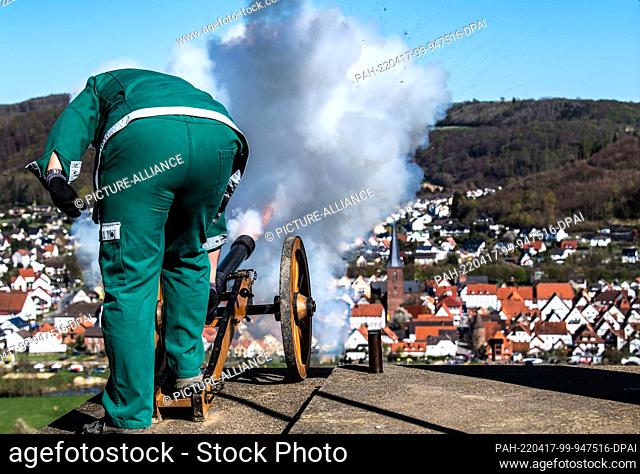 17 April 2022, Lower Saxony, Lügde: A member of the Dechenverein Lügde fires a firecracker shot. When it is dark, the straw in the wheels is lit and the wheels...