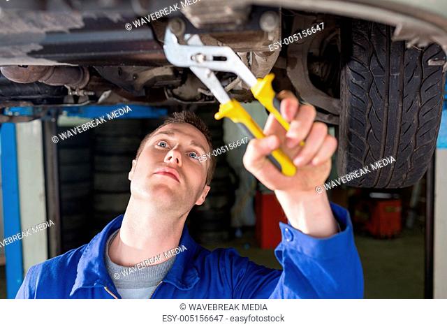 Mechanic repairing car with adjustable pliers