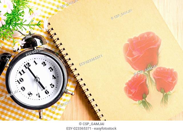 Clock diary brown color with red rose on wooden