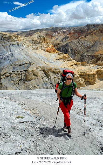 Young woman, hiker, trekker in the surreal landscape typical for Mustang in the high desert around the Kali Gandaki valley, the deepest valley in the world