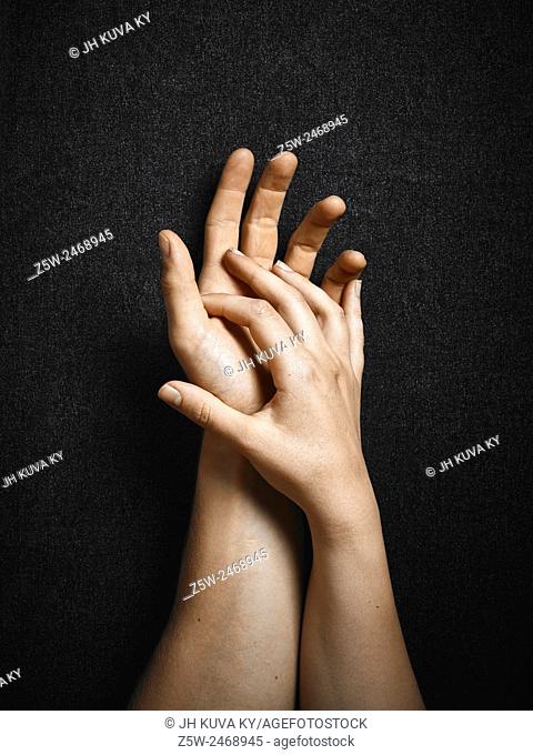 Man and woman, hands connecting together, dark canvas background