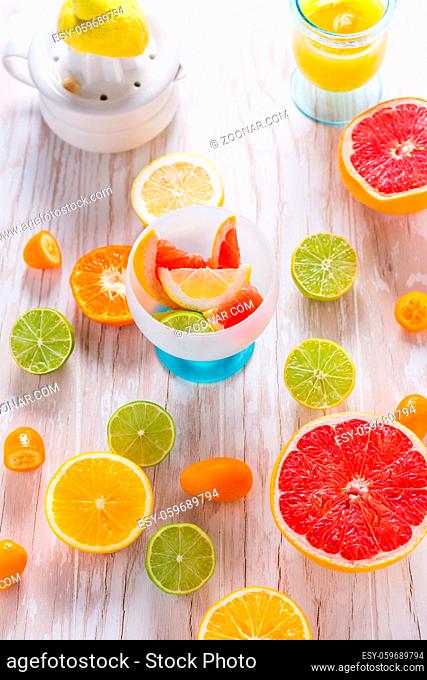 Assortment of citrus fruits on white wooden background. Preparing lemonade, ice tea or summer drink
