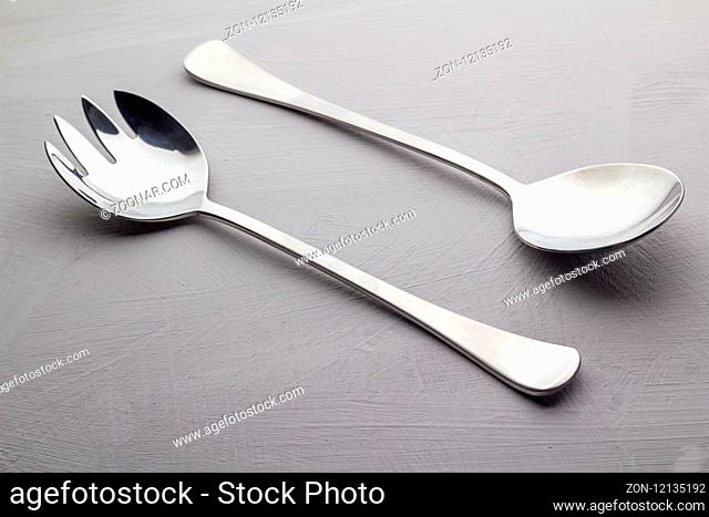Salad server set isolated on grey texture background close up