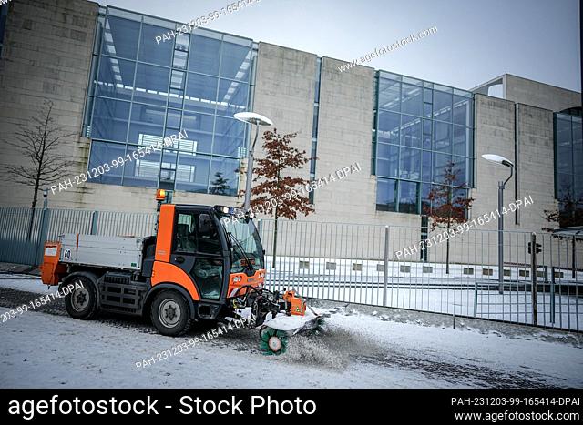 03 December 2023, Berlin: A snow clearing vehicle drives past the Federal Chancellery. In the budget crisis, SPD leader Esken expects the federal budget for...
