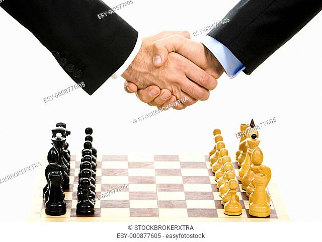 Image of chess-board with business handshake over it