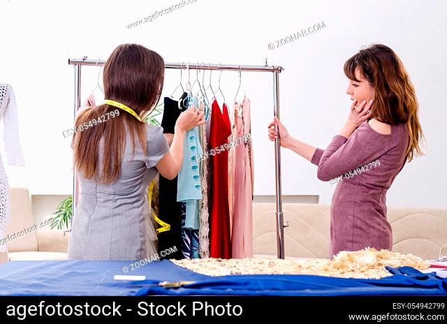 Young beautiful female tailor taking measurements