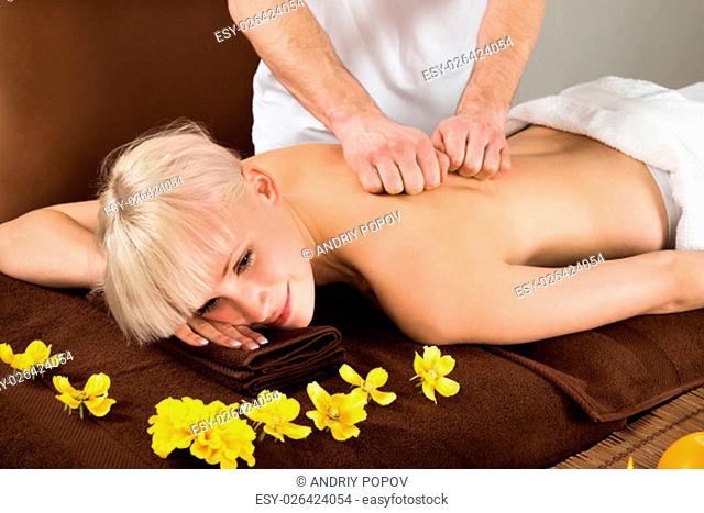 View Of A Young Woman Receiving Back Massage From A Massager In A Beauty Spa