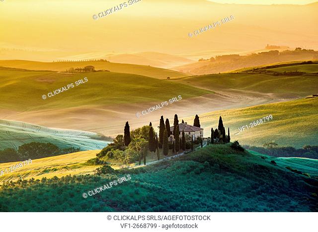 Val d'Orcia, Tuscany, Italy. A lonely farmhouse with cypress and olive trees, rolling hills