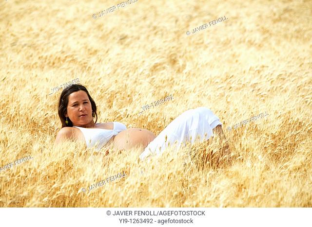 Pregnant woman relaxing in field