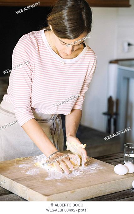 Woman preparing dough, flour and eggs