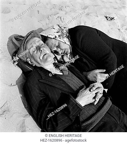 An elderly couple doze on the beach, oblivious to the interest of the photographer, Blackpool, c1946-c1955