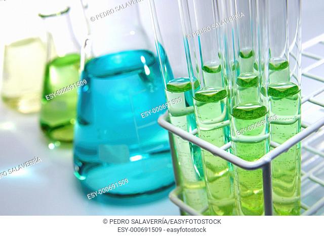 test tubes and flasks with green and blue liquid in a laboratory