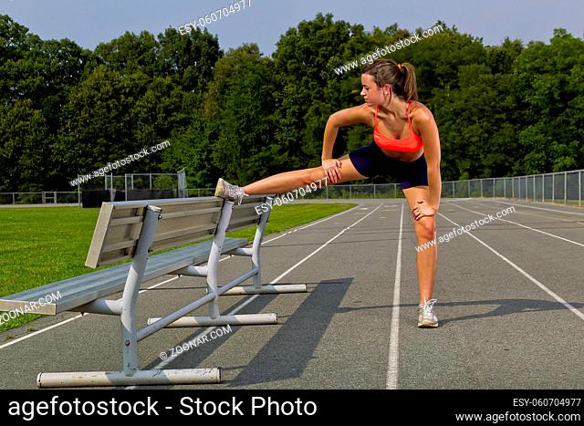 An athletic teenager exercising on a track outdoors
