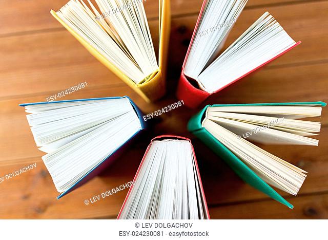 education, school, literature, reading and knowledge concept - close up of books on wooden table