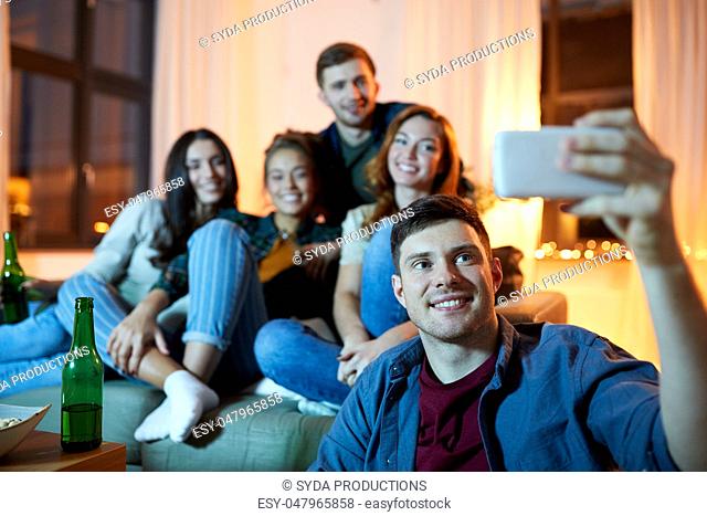 happy friends taking selfie by smartphone at home