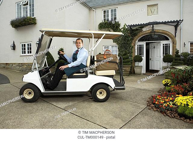 Man driving golf cart with luggage