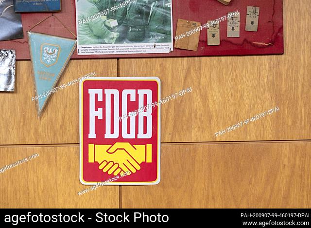 04 September 2020, Saxony-Anhalt, Magdeburg: Workers have found numerous pennants, wall newspapers and posters from GDR times on the premises of the Stadthalle