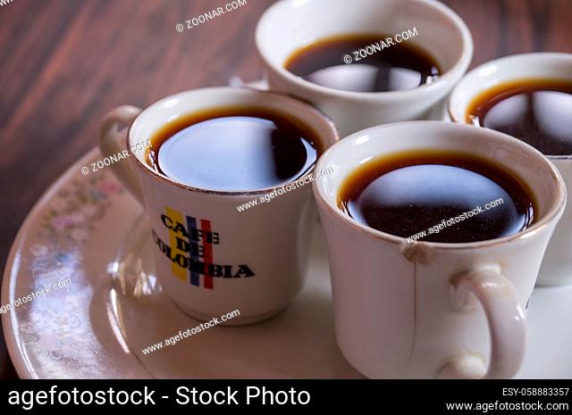 Salento, Colombia on December 10, 2015: Four cups with coffee on a plate. The cups are labeled as Colombian Coffee