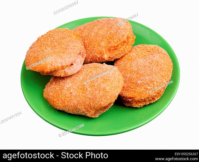 Frozen chicken nuggets with cheese and bacon inside on a green plate. Isolated on white studio food closeup