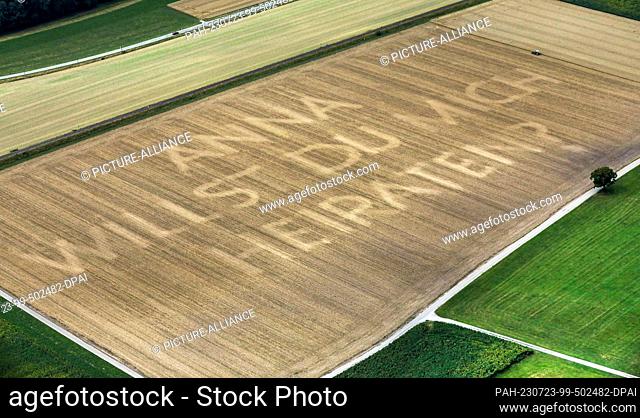 23 July 2023, Baden-Württemberg, Ostrach: A farmer mowed the words ""Anna, will you marry me?"" into a harvested grain field (photo taken from an airplane)