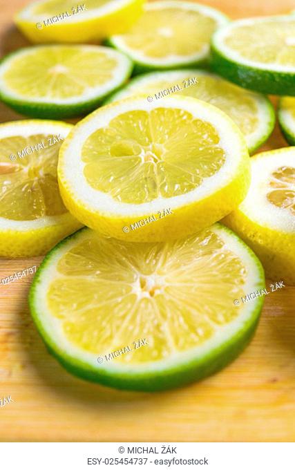 Image of citrus slices - lemon and lime on a wooden background
