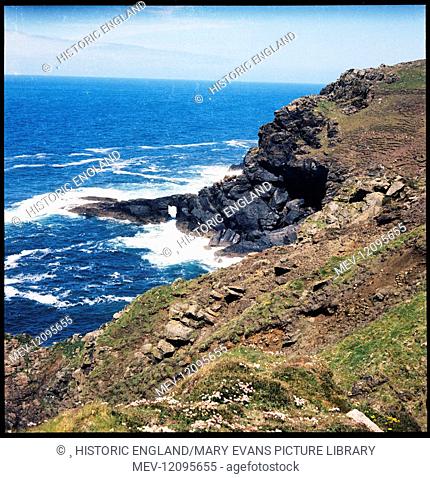 The cliffs at Carn Vellan and waves crashing around the natural arch in the distance