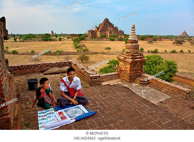 Selling paintings while viewing the 12th century DHAMMAYANGYI PAHTO or TEMPLE is the largest in BAGAN and was probably built by Narathu - MYANMAR - 13/05/2012