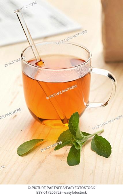 Glass with tea and fresh Stevia rebaudiana leaves as sweetener