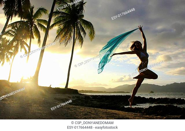 Silhouette of young woman jumping at Las Galeras beach