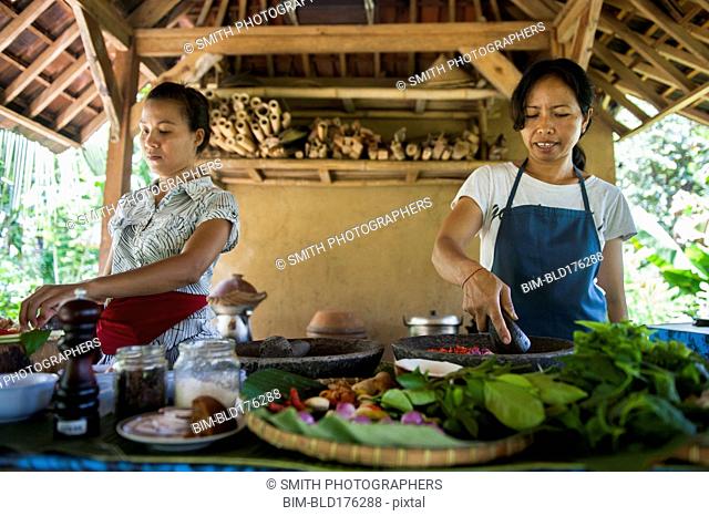 Asian chefs cooking in outdoor kitchen