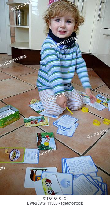 small boy with fallen cards