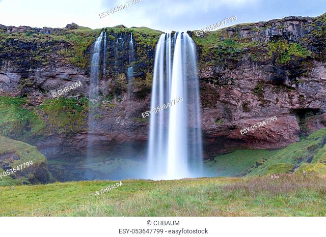 Night shot of world famous Seljalandsfoss, a majestic waterfall in southern Iceland, coming down over a cliff, fed by a glacier