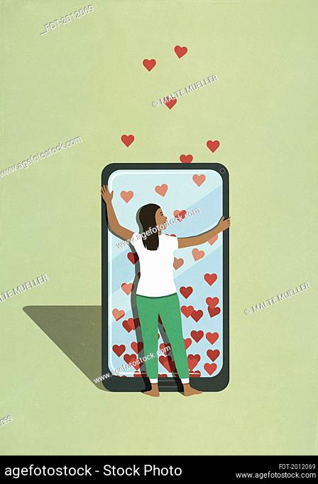 Woman hugging smart phone with hearts