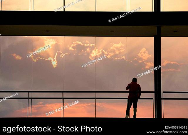 Silhouette view of young businessman in a modern office building interior with panoramic windows