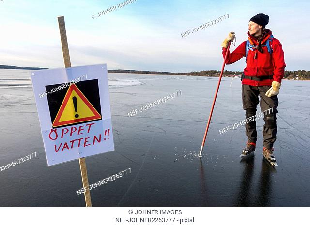 Warning sign on ice, Ice-skater on background