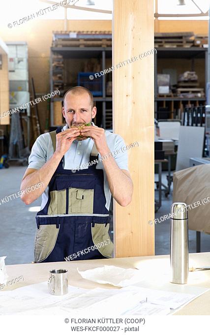 Craftsman in workshop having breakfast break