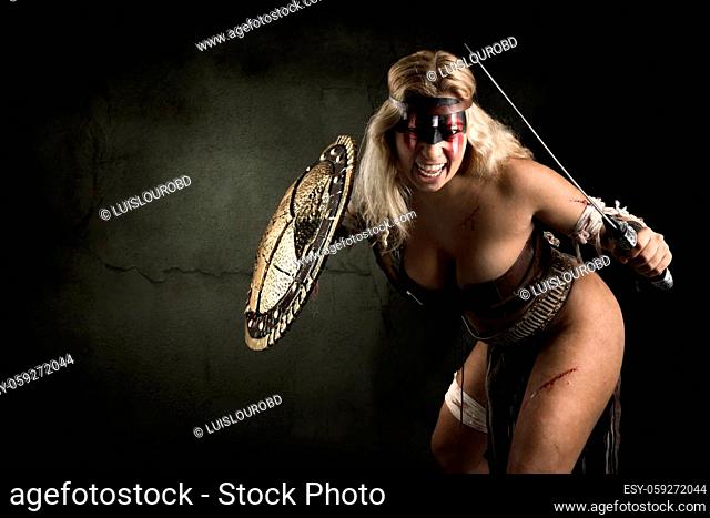 Ancient woman warrior or Gladiator posing in a dark background