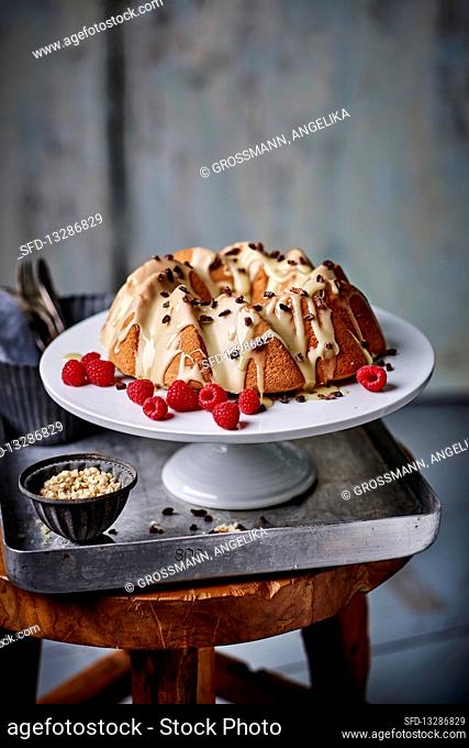 A Bundt cake with white chocolate glaze and raspberries