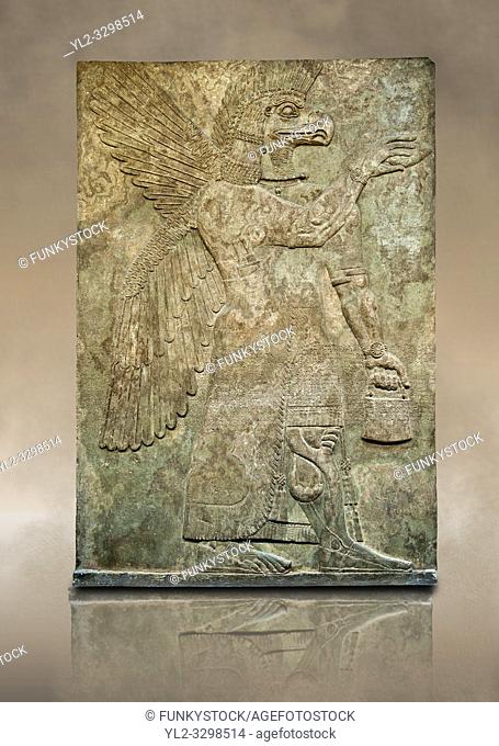 Assyrian relief sculpture panel of a protective spirit with an eagles Head from Nimrud, Iraq. The spirit is holding a symbolic fir cone and is sprinkling holy...