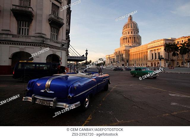 Old American cars used as taxi at the parking lot with the Capitolio building at the background in Central Havana, Cuba, West Indies, Central America