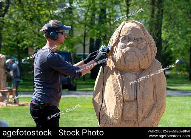 11 May 2023, Mecklenburg-Western Pomerania, Zinnowitz: Tim Weigelt, wood sculptor makes a wooden sculpture of Wolfgang Bordel