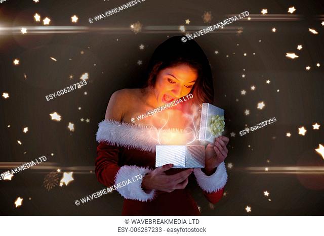 Sexy santa girl opening gift against bright star pattern on black