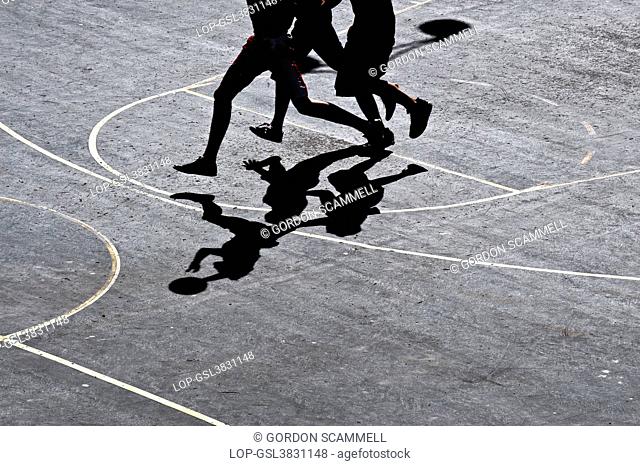 England, City of Brighton and Hove, Brighton. Shadows cast on a court by basketball players