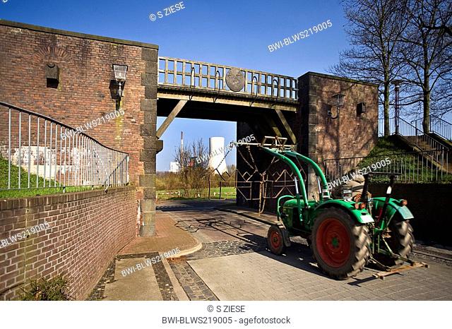 tractor in front of a bridge and in the background coal-fired power plant in Duisburg-Walsum, Germany, North Rhine-Westphalia, Ruhr Area, Rheinberg