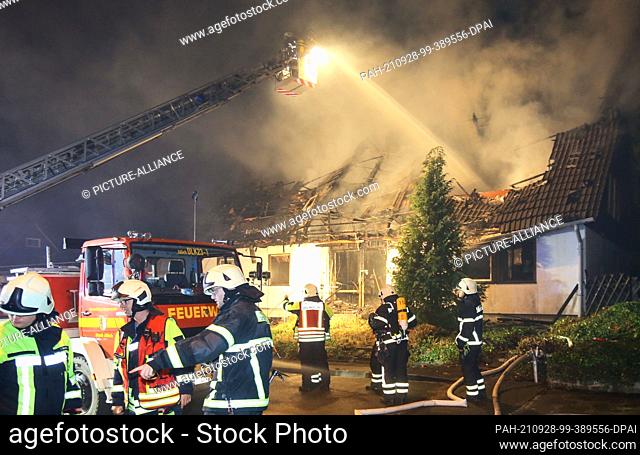 27 September 2021, North Rhine-Westphalia, Jülich: Firefighters extinguish the fire in an apartment building. Nine injured, a destroyed fire engine