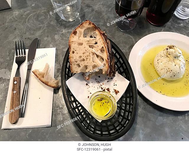 Sourdough bread with olive oil on a restaurant counter (Italy)